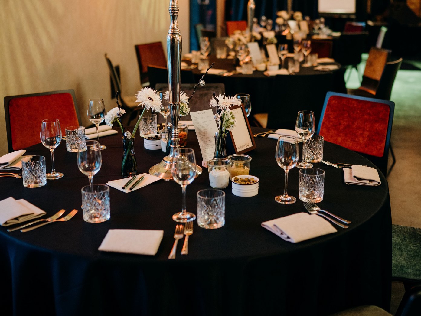 Festlich eingedeckter Rundtisch mit großem Kerzenständer in der Mitte